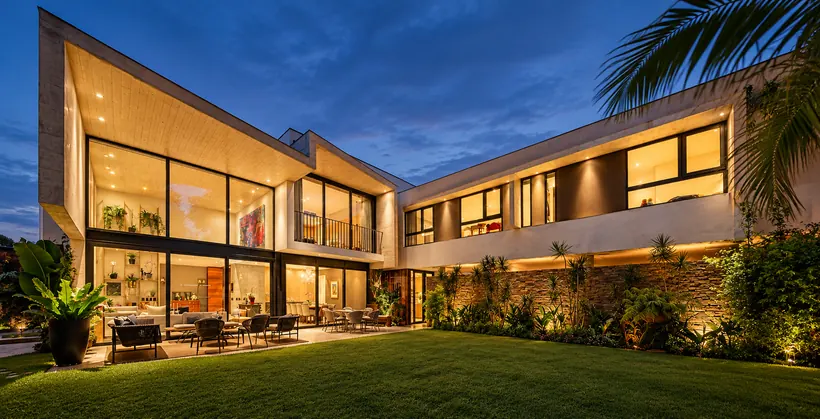 Vivienda contemporánea con grandes ventanales, al atardecer