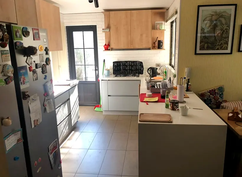 Cocina remodelada con muebles blancos y madera